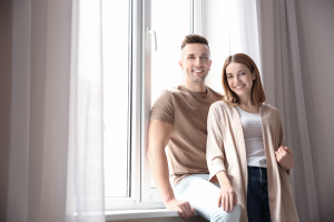 Happy couple standing by a new window